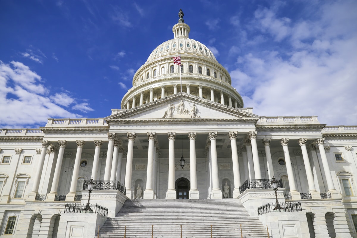 The United States Capitol building dome against a blue sky in Washington, D.C.