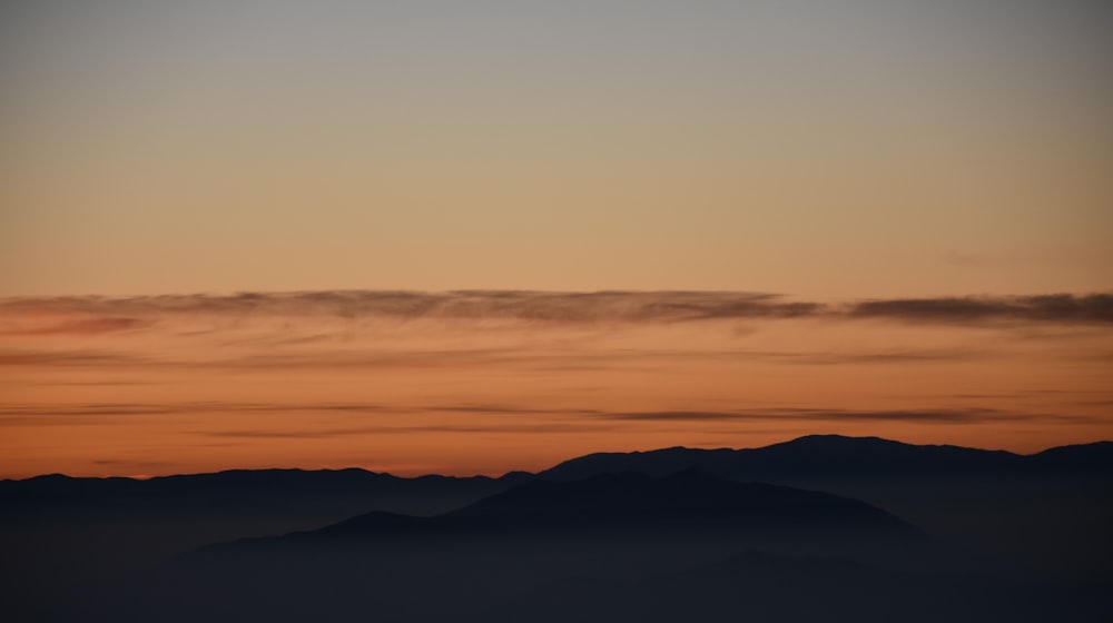 Silhouettenfotografie der Berge während der goldenen Stunden