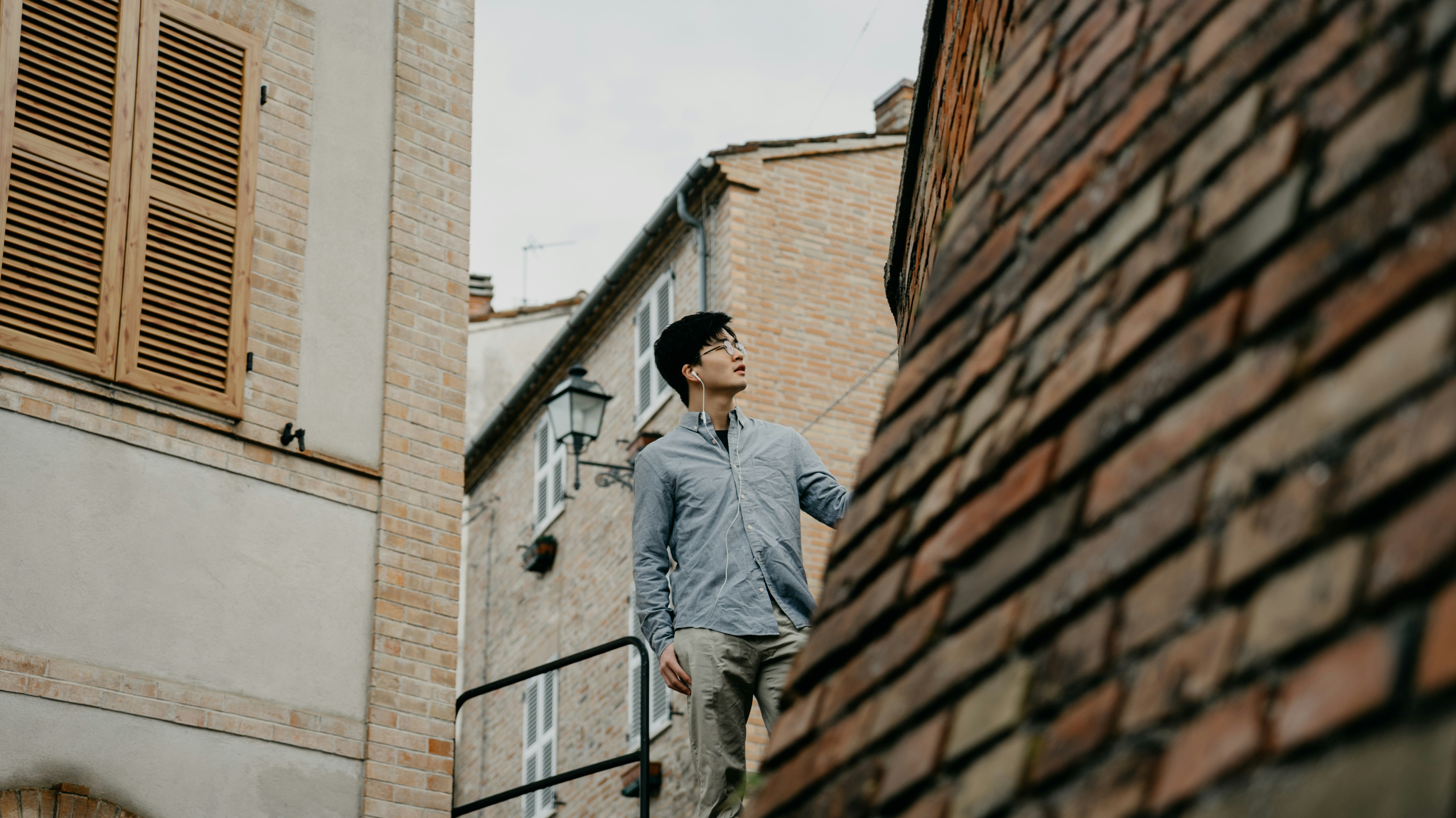 man standing near brown concrete house