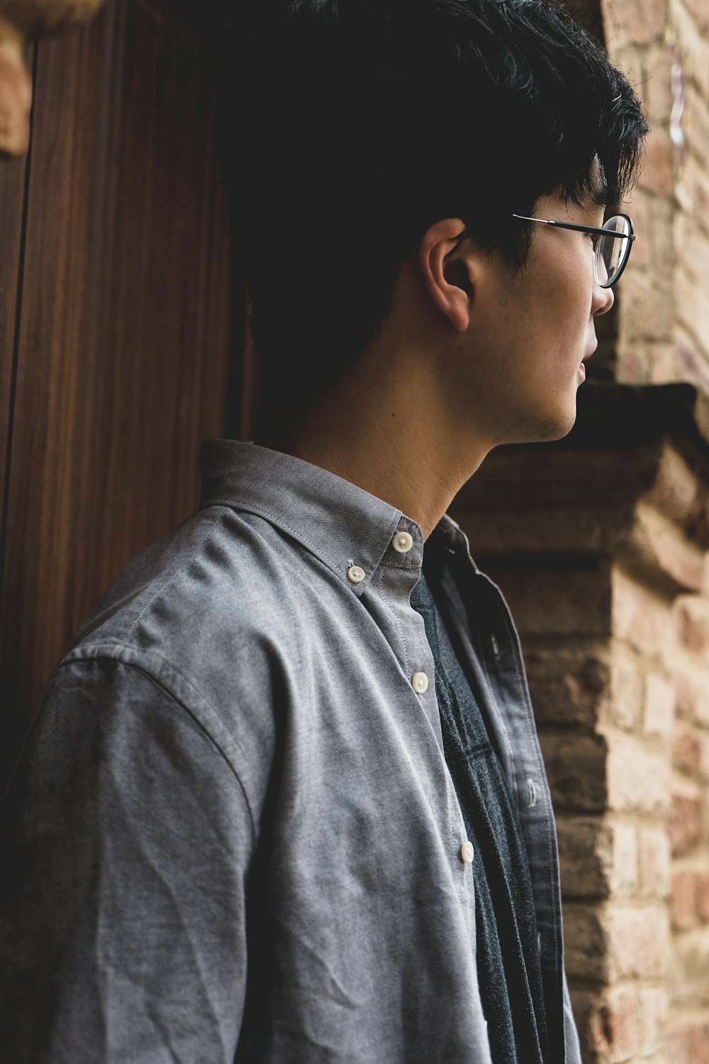 selective focus photography of man near brown brick wall during daytime