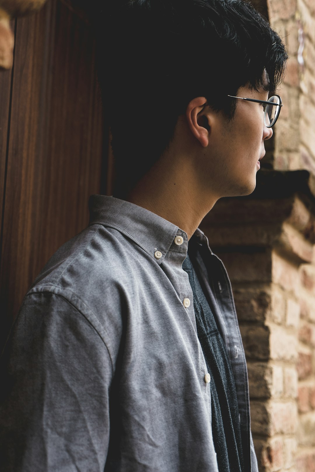 selective focus photography of man near brown brick wall during daytime