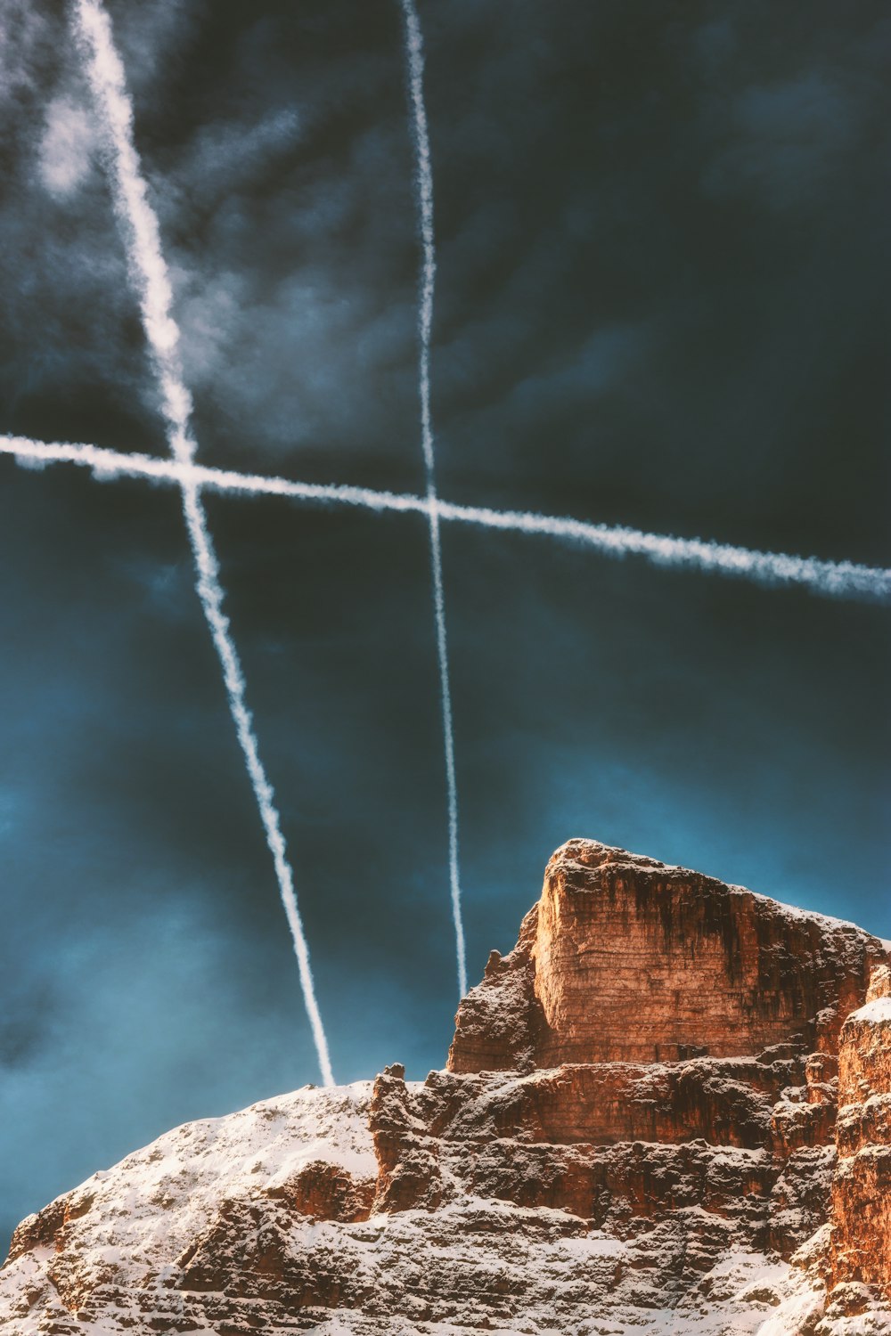 飛行機雲の下の茶色の岩層