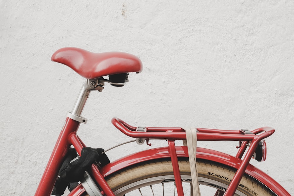 Bicicleta roja cerca de la pared blanca