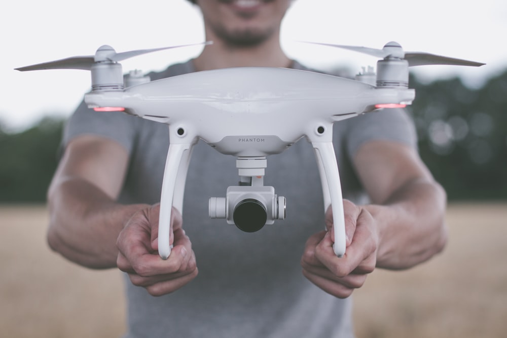 pessoa segurando drone quadricóptero