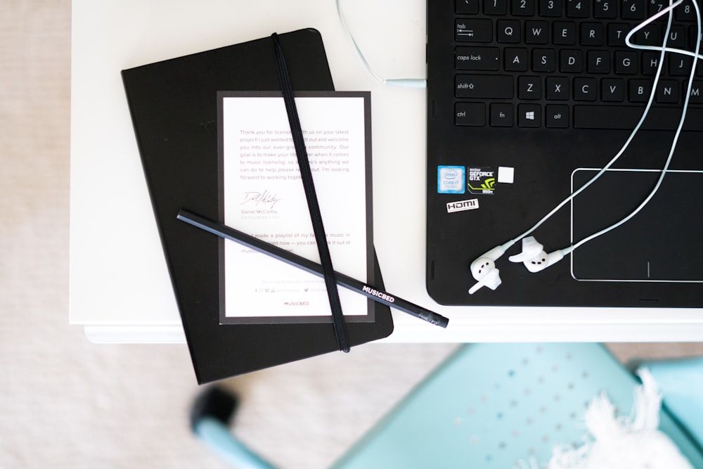 black pens beside laptop computer placed on table