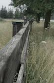 A weathered wooden fence bordering a sprawling Texas ranch at sunset.