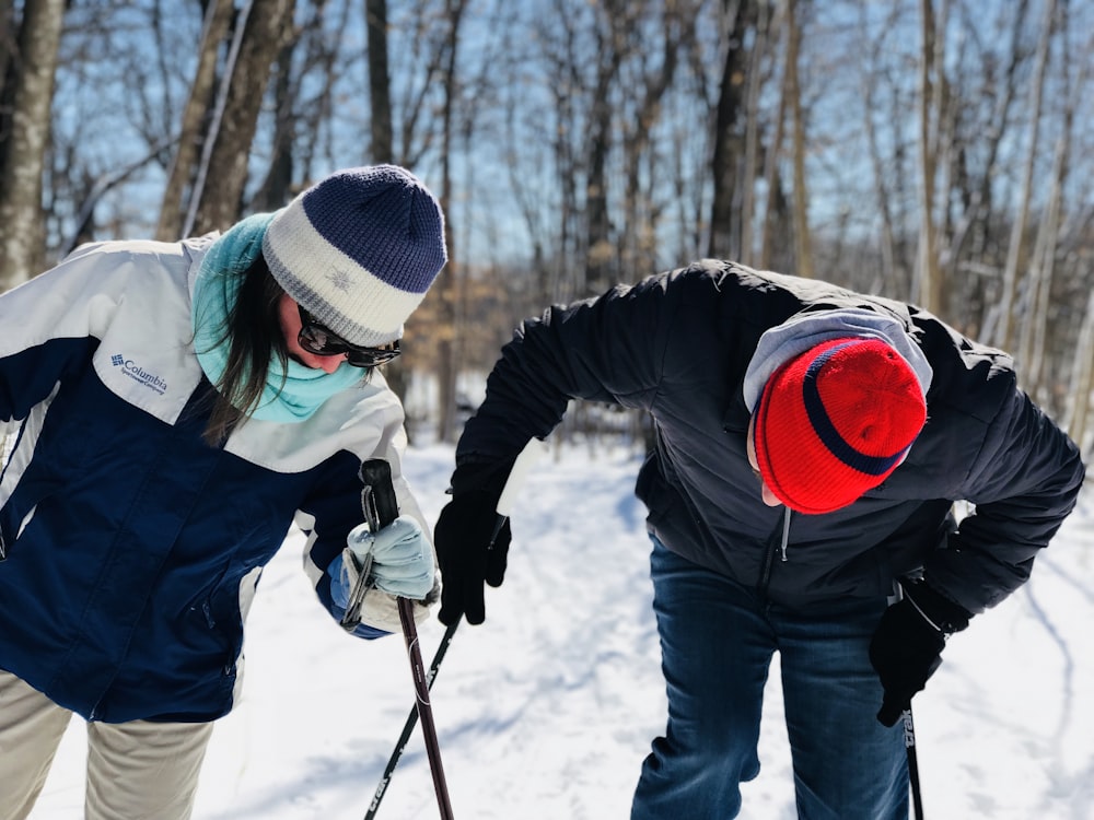 two people holding black ski pole looking down during daytime