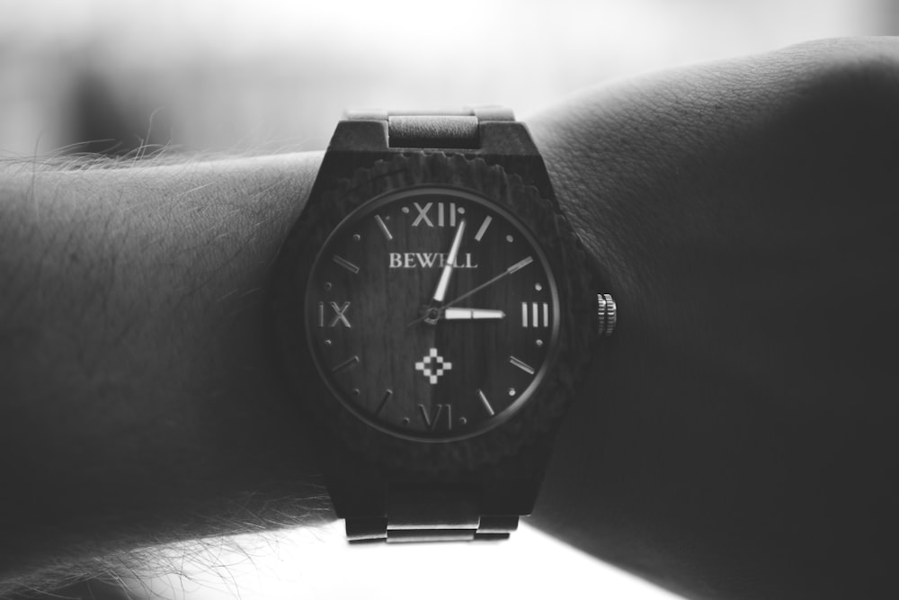 grayscale photography of person wearing black analog watch