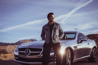 man sitting on Mercedes-Benz car's hood