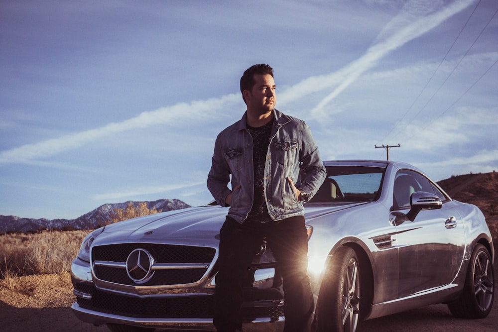 man sitting on Mercedes-Benz car's hood