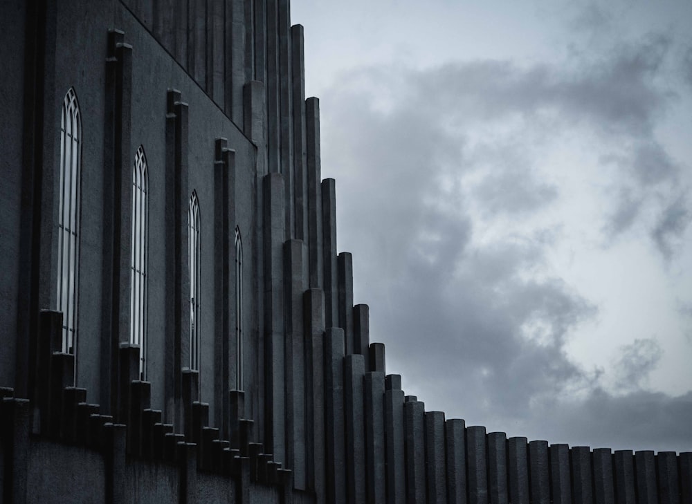 grayscale photography of building under cloudy sky