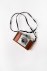 brown and gray SLR camera on white surface