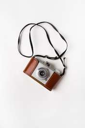 brown and gray SLR camera on white surface