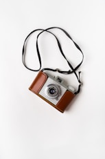 brown and gray SLR camera on white surface