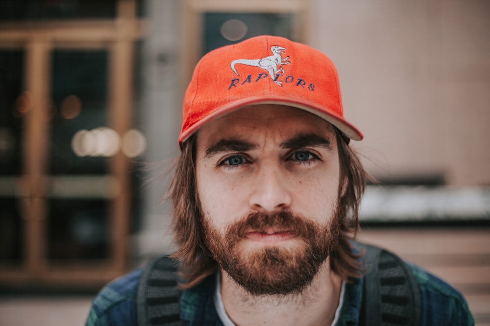 オレンジ色の猛禽類の帽子をかぶった男の接写写真