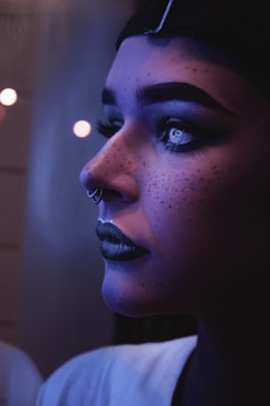 photo of woman with black lipsticks and nose piercings captured inside dim light room