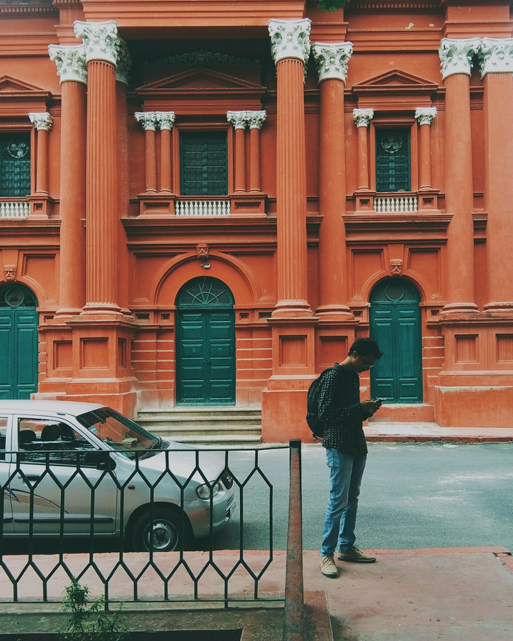 man standing in front of white car during daytime