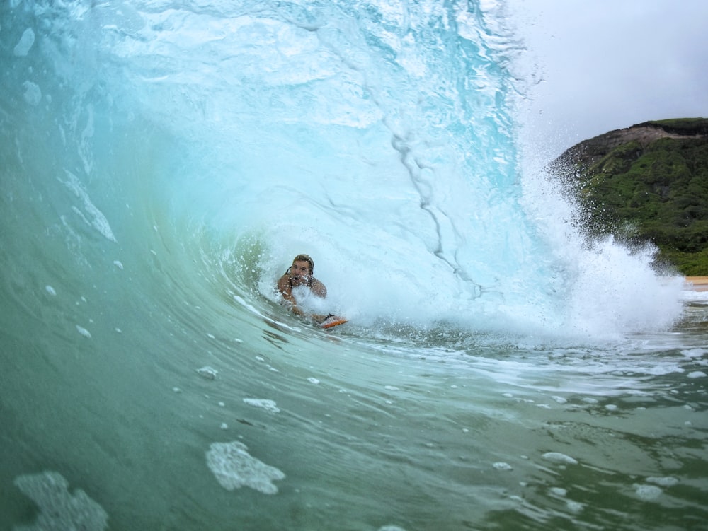 person surfing underneath sea waves