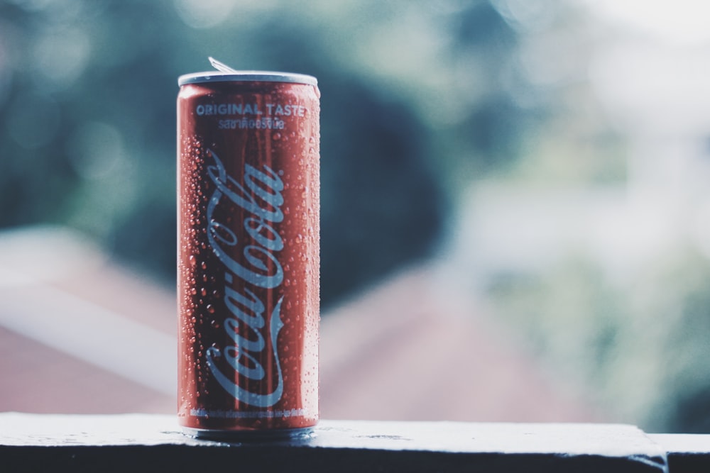 fotografia bokeh della lattina di soda Coca-Cola durante il giorno