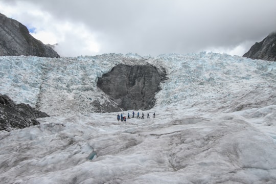 people standing on Glacier Bay, Iceland in Franz Josef Glacier New Zealand