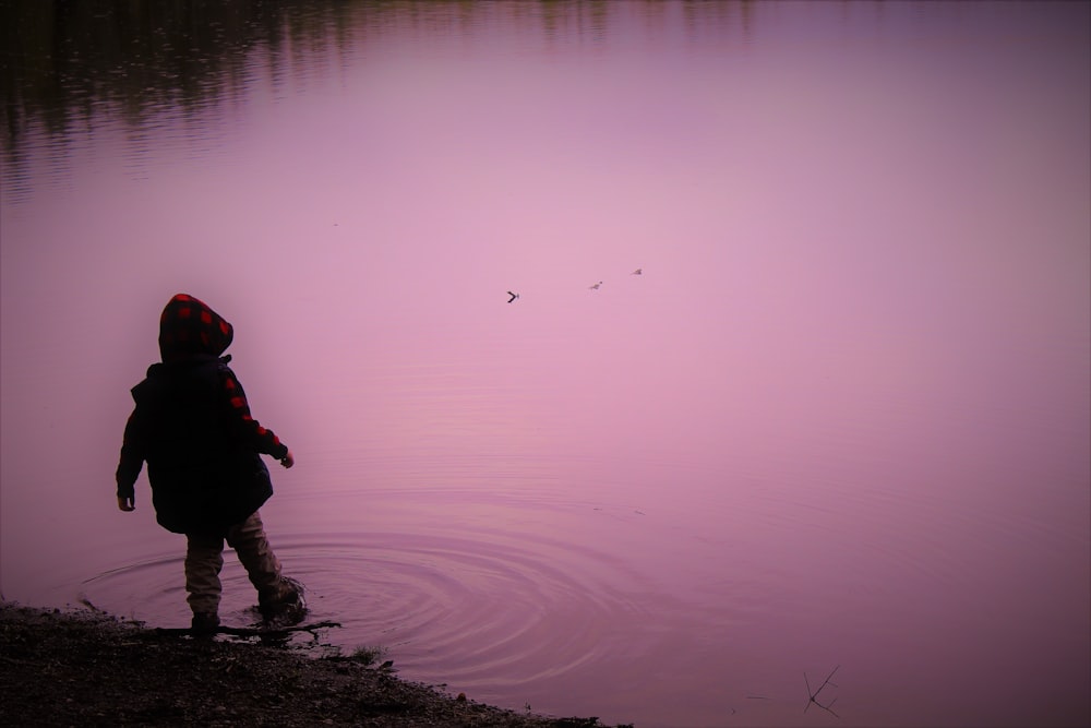 children dipping his right foot in water