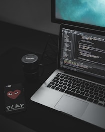 MacBook Pro open near black Canon mug