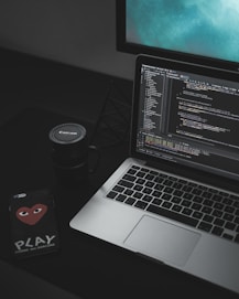 MacBook Pro open near black Canon mug