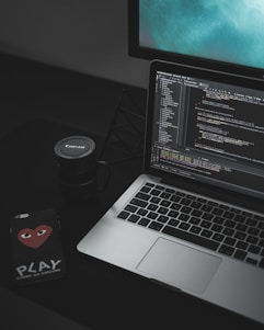 MacBook Pro open near black Canon mug