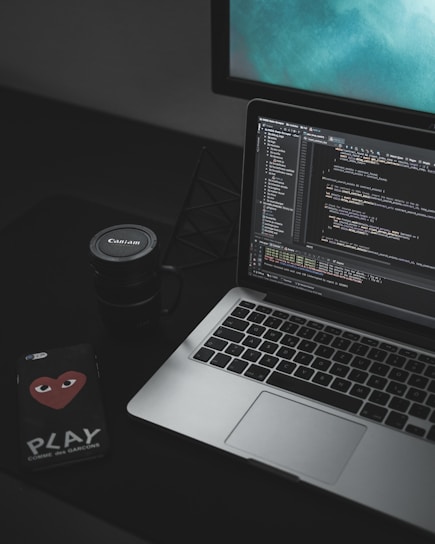 MacBook Pro open near black Canon mug