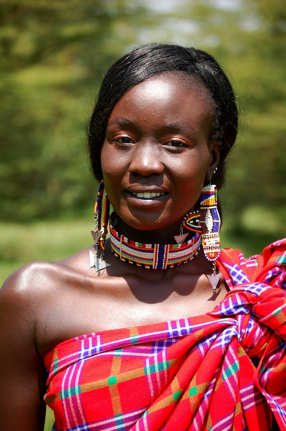 woman in red and brown top smiling