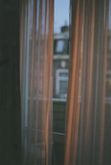 Large window with city views and soft curtains in the King Suite.