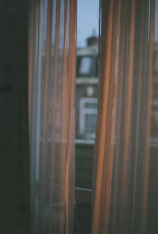 Elegant black blackout curtains framing a large window with a cityscape view at dusk.