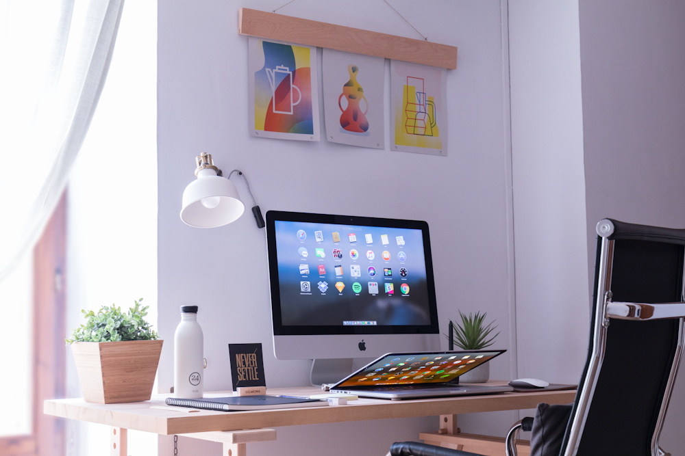 iMac blanco sobre escritorio de madera marrón