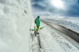 man standing besides green bicycle