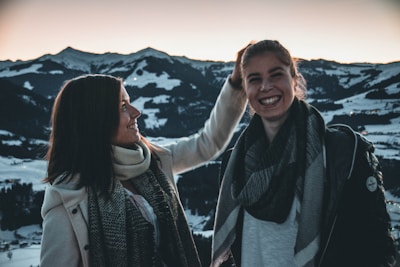 A smiling companion chatting happily with a traveler against the backdrop of Himalayan mountains.
