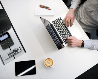 person using laptop on white wooden table