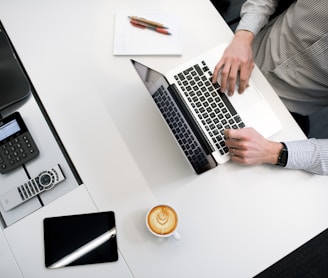 person using laptop on white wooden table