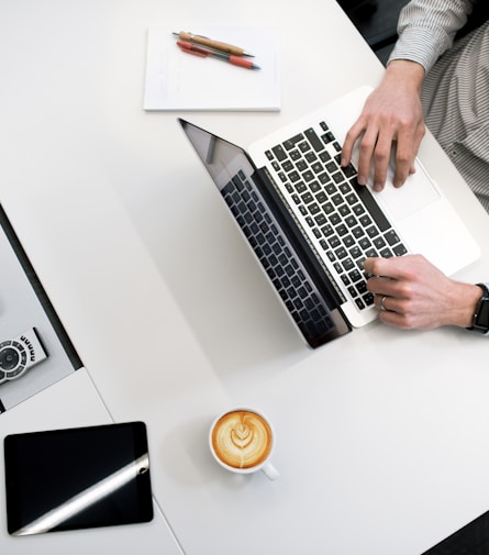 person using laptop on white wooden table