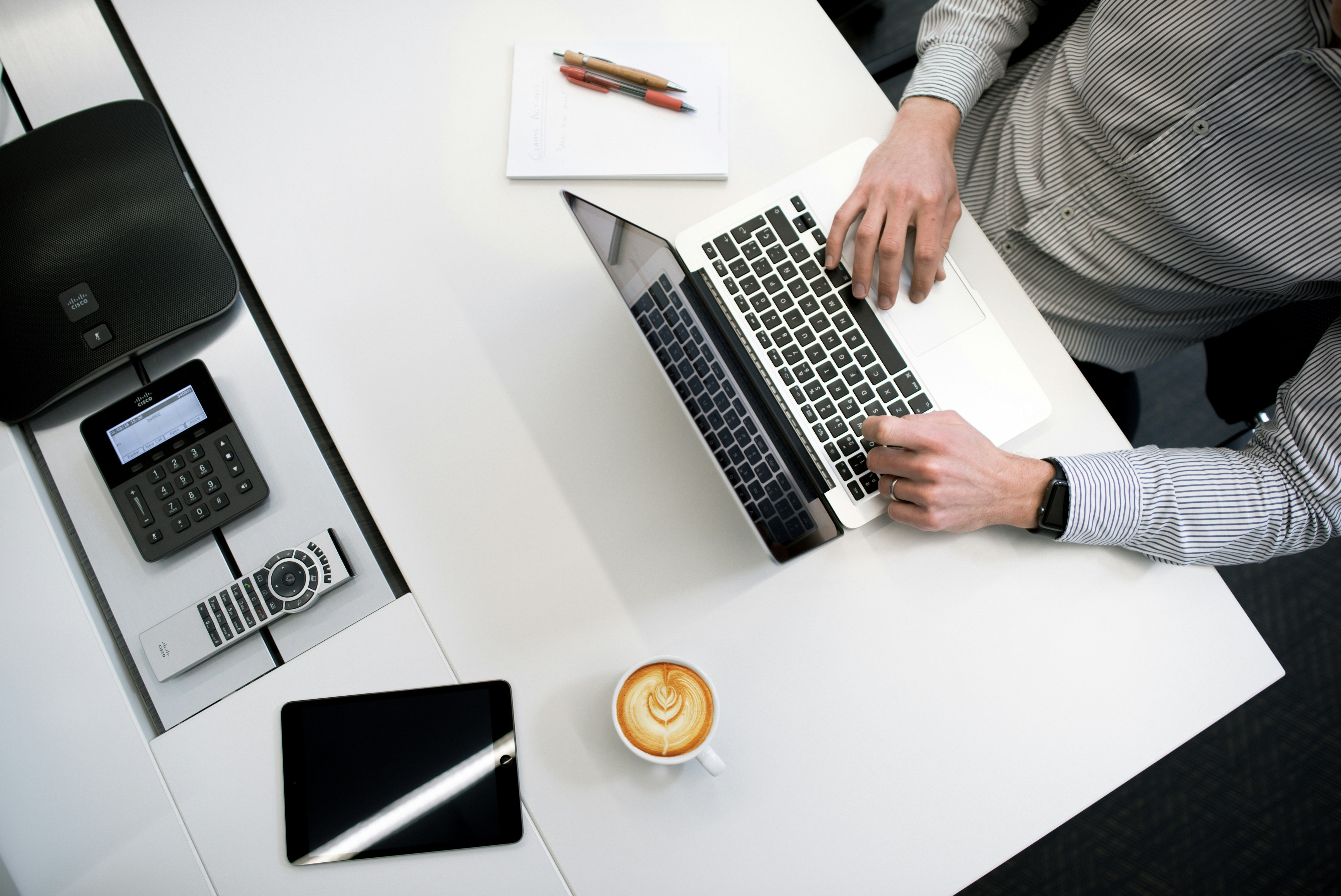 personne utilisant un ordinateur portable sur une table blanche en bois