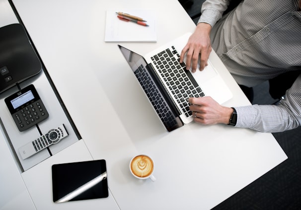 person using laptop on white wooden table