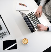 person using laptop on white wooden table