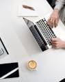 person using laptop on white wooden table