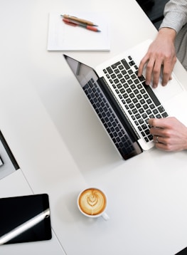 person using laptop on white wooden table