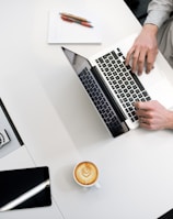 person using laptop on white wooden table