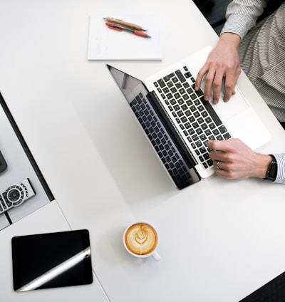 person using laptop on white wooden table