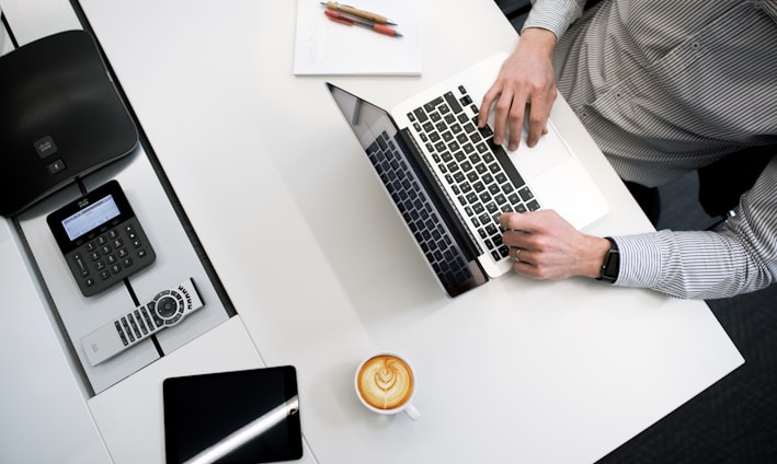 person using laptop on white wooden table