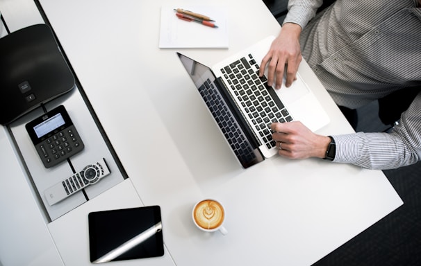 person using laptop on white wooden table