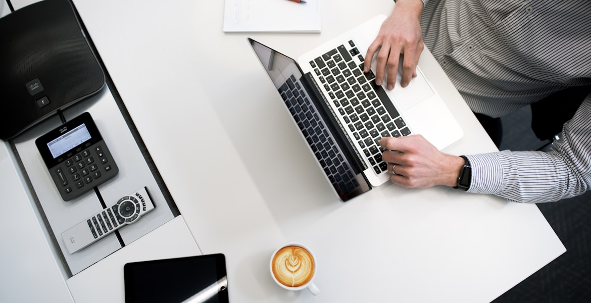 person using laptop on white wooden table