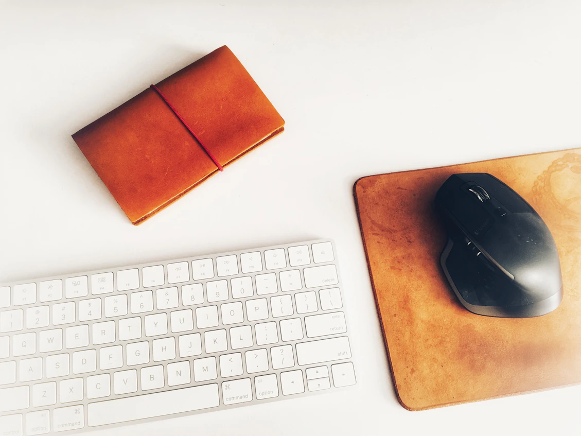 A clean, modern workspace with a laptop, notebook, and a red pen on a white desk, reflecting a professional nonprofit environment.