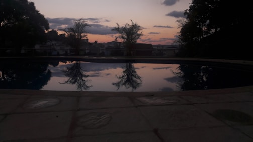 Water tanker delivering to a residential swimming pool at sunset.